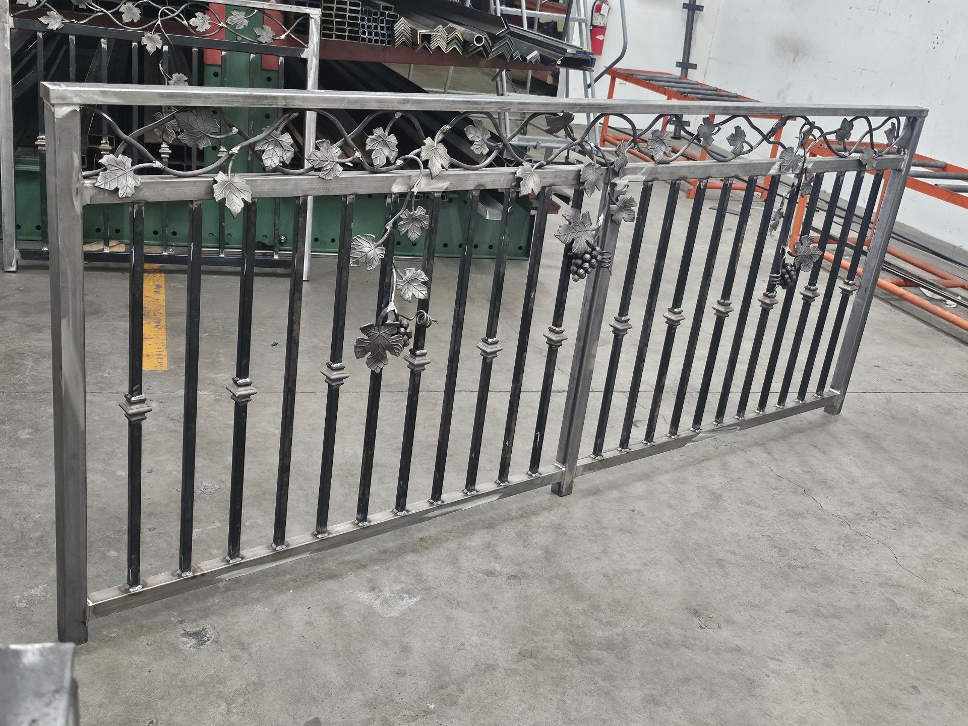 Custom wrought iron railing in progress, featuring vertical pickets with decorative collars and a detailed grapevine top rail. Built for both safety and visual appeal, this piece blends structural integrity with ornamental craftsmanship. Designed and fabricated in-house for residential and commercial properties across the entire Bay Area.