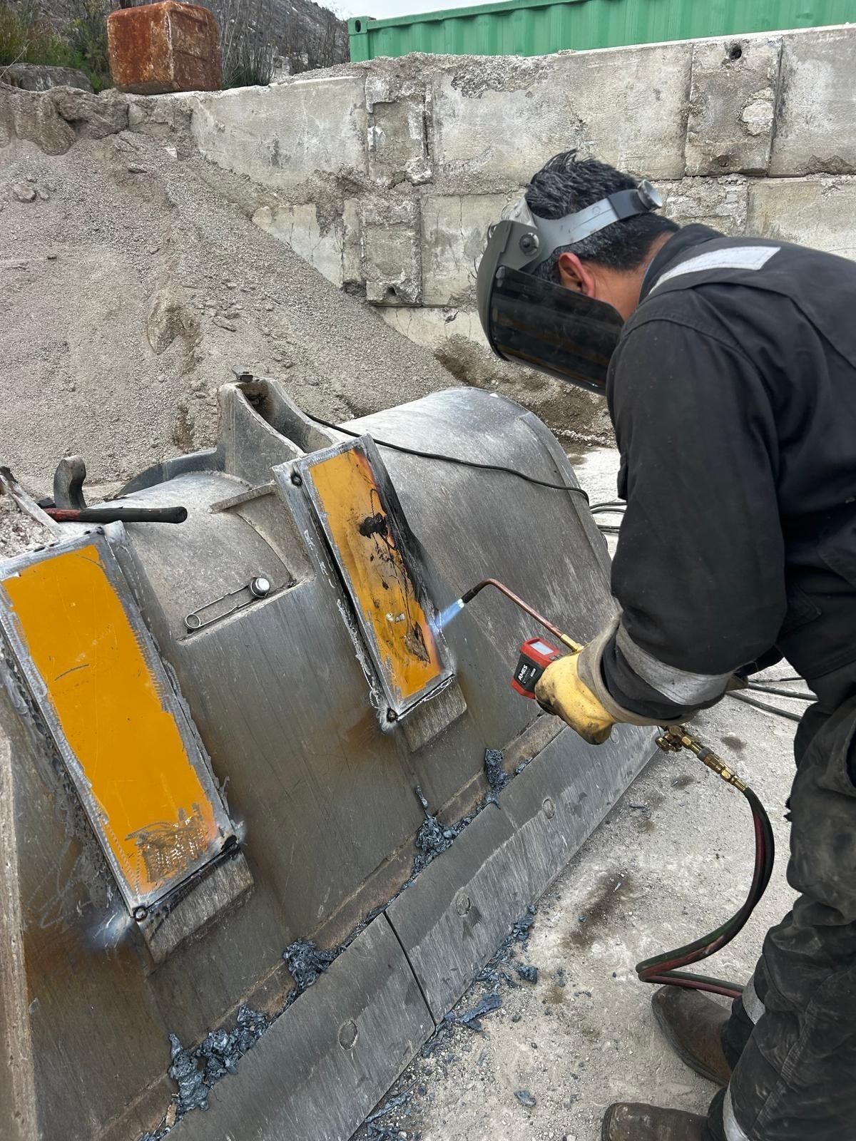 a welded loader bucket repair welded and there is fire from a torch 