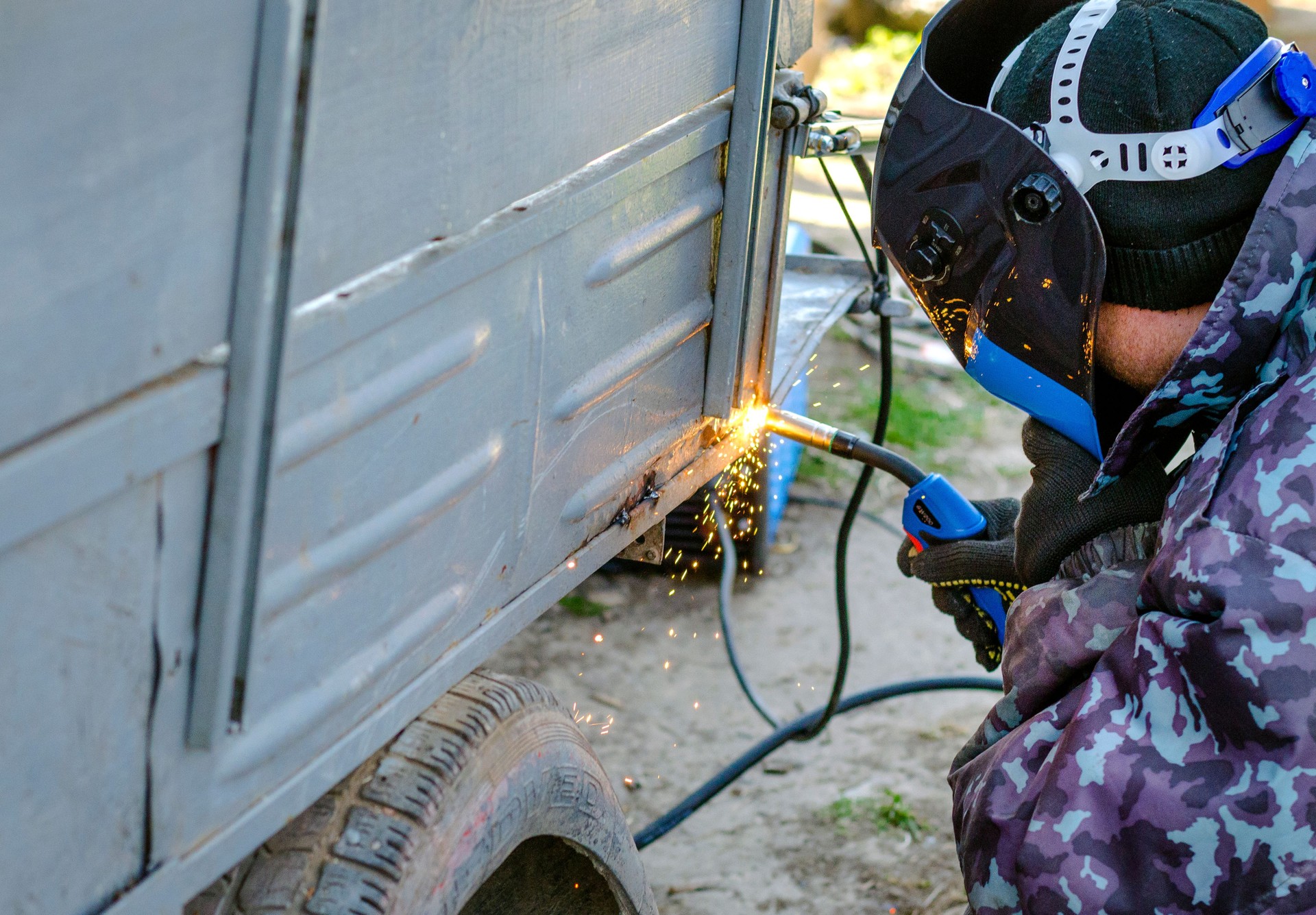 welder works at home in a protective mask without gloves