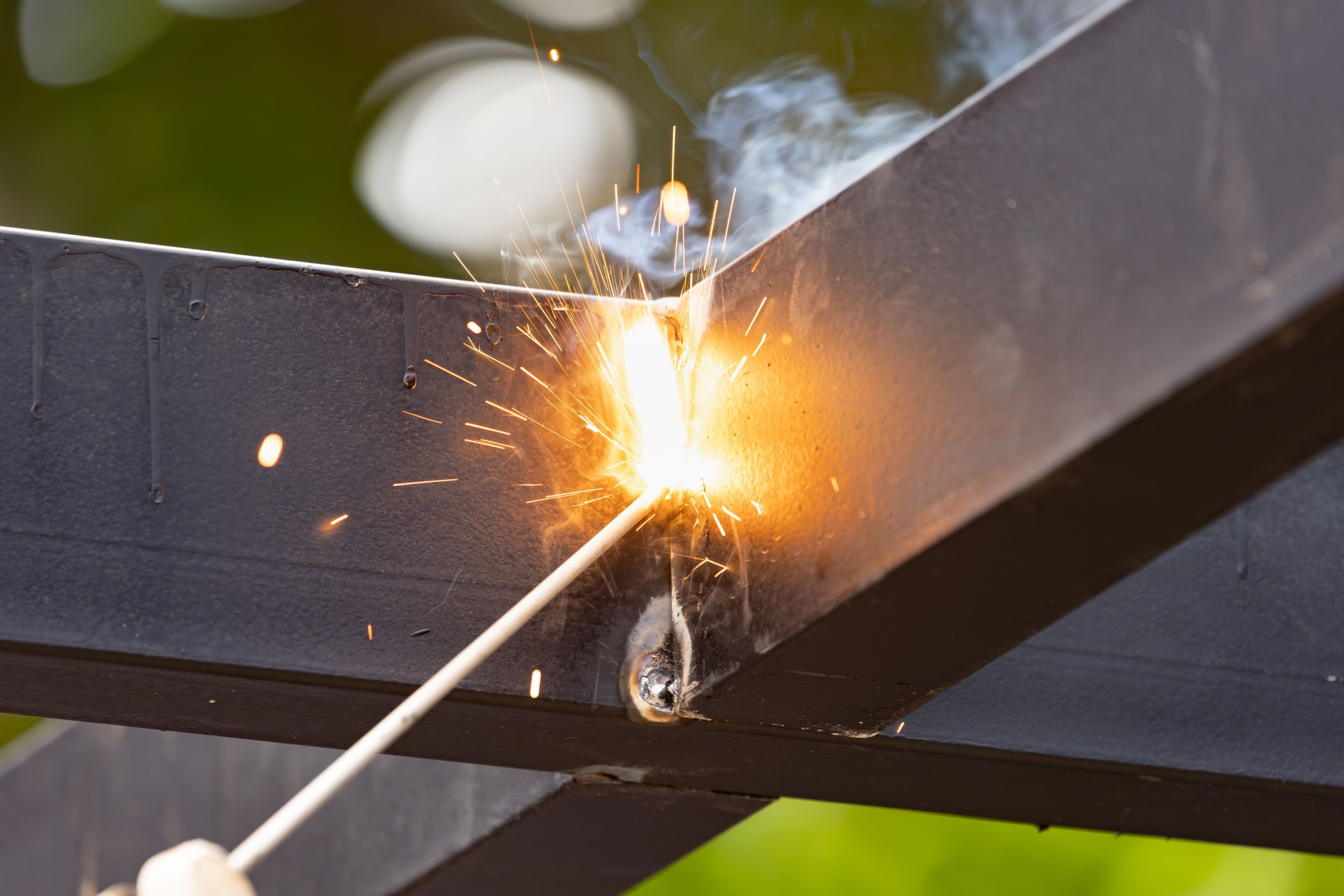 worker welding steel pipe in construction site.